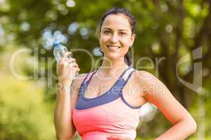 Fit brunette holding her water bottle