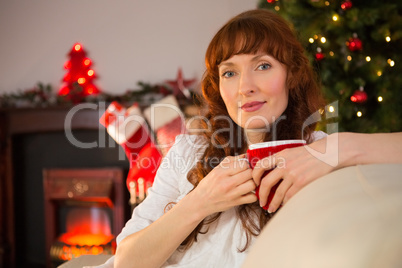 Pretty redhead holding a mug of hot chocolate at christmas
