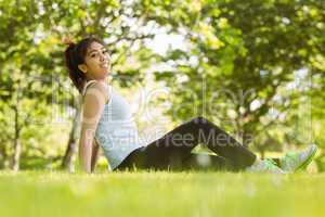 Healthy woman sitting on grass in park