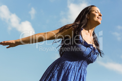 Pretty brunette in blue dress feeling free