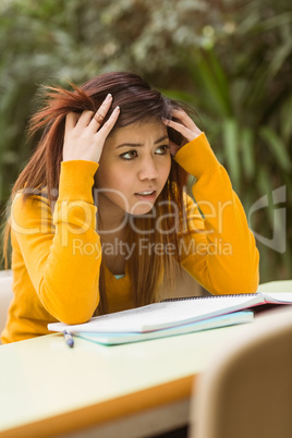Frustrated female college student doing homework