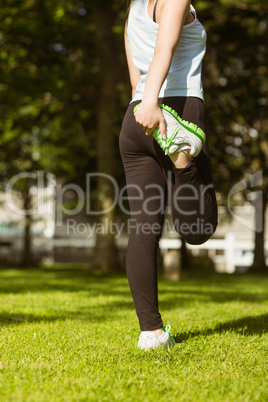 Healthy woman stretching leg in park