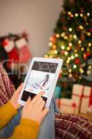 Redhead woman sitting on couch using tablet at christmas