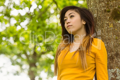 Beautiful woman against tree in park
