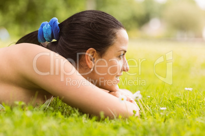 Happy fit brunette lying on the grass