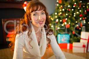 Redhead woman sitting on floor using laptop at christmas