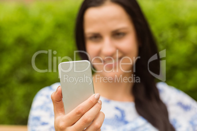 Smiling brunette using her mobile phone