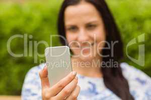 Smiling brunette using her mobile phone