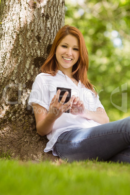 Pretty redhead smiling and holding her phone