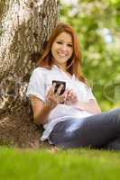 Pretty redhead smiling and holding her phone