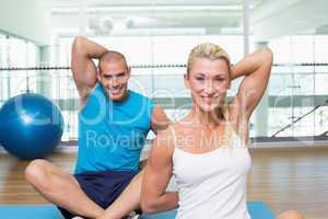 Couple stretching hands behind back in yoga class