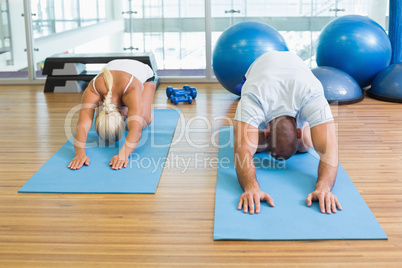 Couple in bending posture at fitness studio