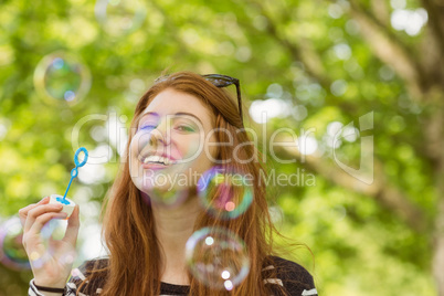Woman blowing bubbles at park Woman blowing bubbles at park