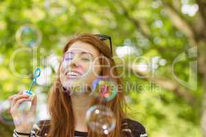 Woman blowing bubbles at park