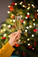 Redhead holding glass of champagne on couch at christmas