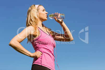 Fit blonde drinking from her water bottle