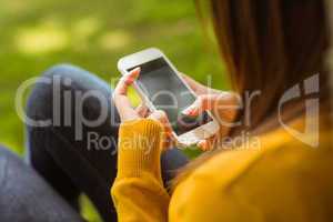 Woman text messaging in park