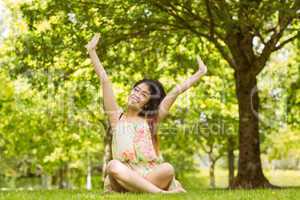 Relaxed young woman sitting in park