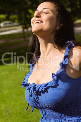 Pretty brunette in blue dress enjoying the sunshine