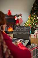 Redhead using laptop on the armchair at christmas