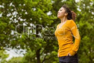 Beautiful woman with eyes closed in park