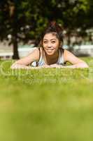 Happy healthy woman lying on grass