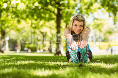 Fit blonde stretching on the grass