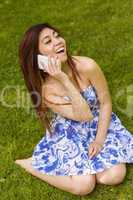 Cheerful woman using mobile phone in park