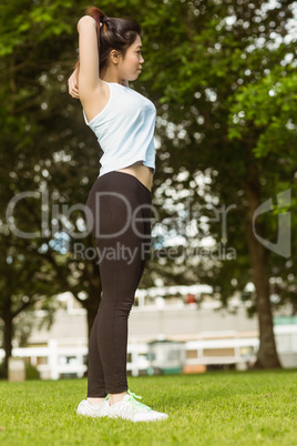 Healthy woman stretching hands in park