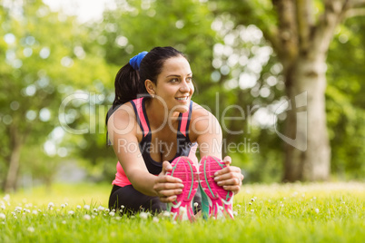 Fit brown hair stretching on the grass