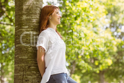 Portrait of a pretty redhead leaning against trunk Portrait of a pretty redhead leaning against trunk
