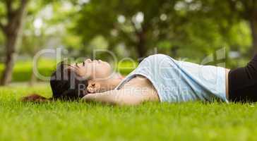 Healthy woman lying on grass in park