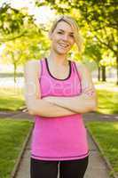 Fit blonde smiling at camera in the park