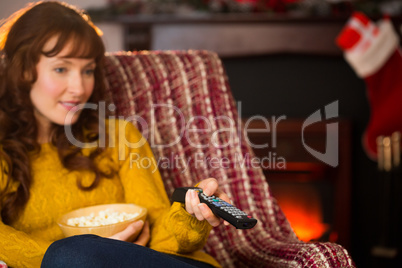 Pretty redhead watching television on couch at christmas