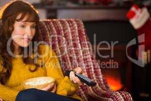 Pretty redhead watching television on couch at christmas