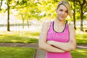 Fit blonde smiling at camera in the park