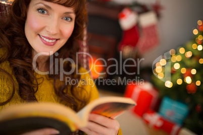 Peaceful redhead reading a book at christmas