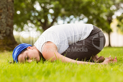 Brunette relaxing and meditating on grass