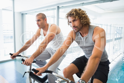 Men working on exercise bikes at gym