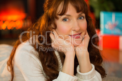 Smiling woman is resting her head on her hands