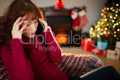 Concentrated redhead on the phone at christmas