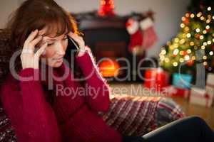 Concentrated redhead on the phone at christmas