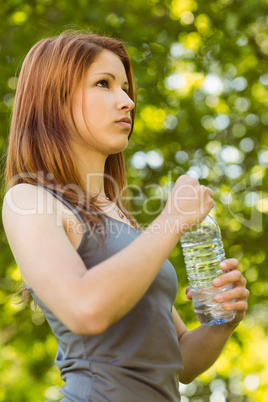 Pretty redhead holding a bottle of water