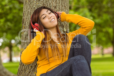 Relaxed woman enjoying music in park