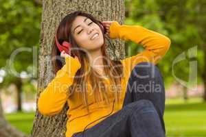 Relaxed woman enjoying music in park