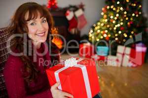 Happy redhead holding a gift at christmas