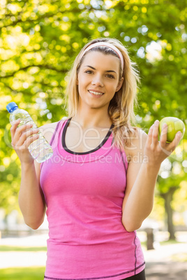 Fit blonde holding water and apple