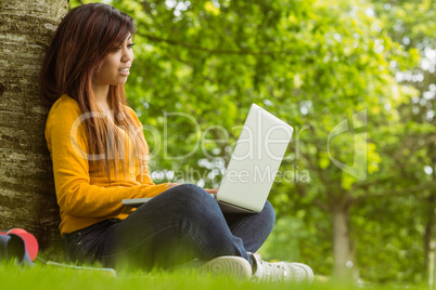 Relaxed young woman using laptop in park