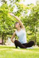 Healthy woman stretching hand in park