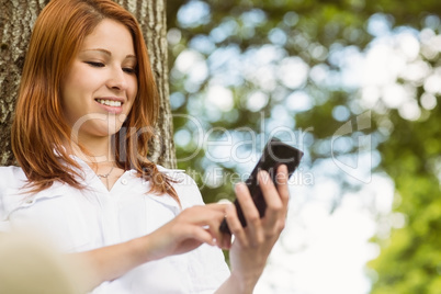 Pretty redhead text messaging on her phone